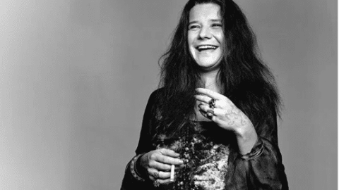 Black and white portrait of Janis Joplin laughing, holding a cigarette as photographed by by Richard Avedon in New York on August 28, 1969.