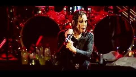 Ozzy Osbourne holding on to the mic and sweating on stage