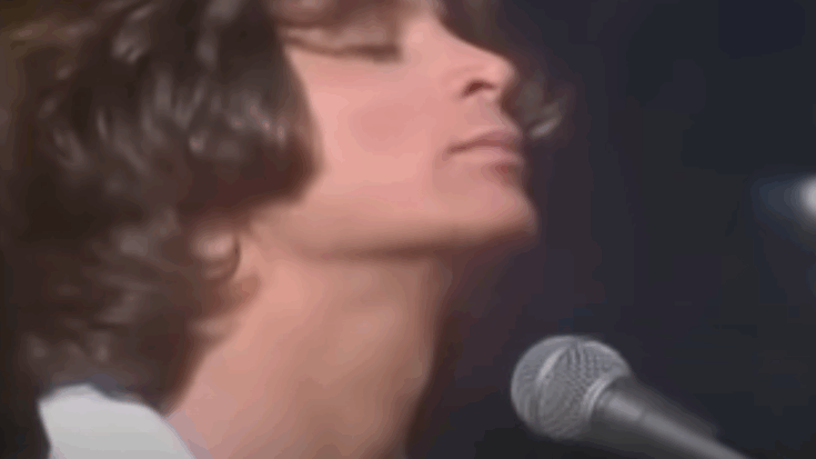 Eric Carmen performing live in the 1970s, eyes closed in an emotional moment behind the microphone.