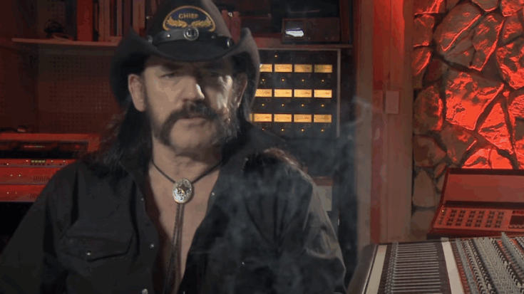 Lemmy Kilmister sits in a dimly lit recording studio wearing his signature cowboy hat and bolo tie, surrounded by smoke and vintage audio equipment.
