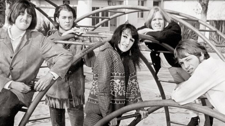 Black-and-white photo of 1960s folk rock band The Rose Garden posing together on a playground climbing frame.