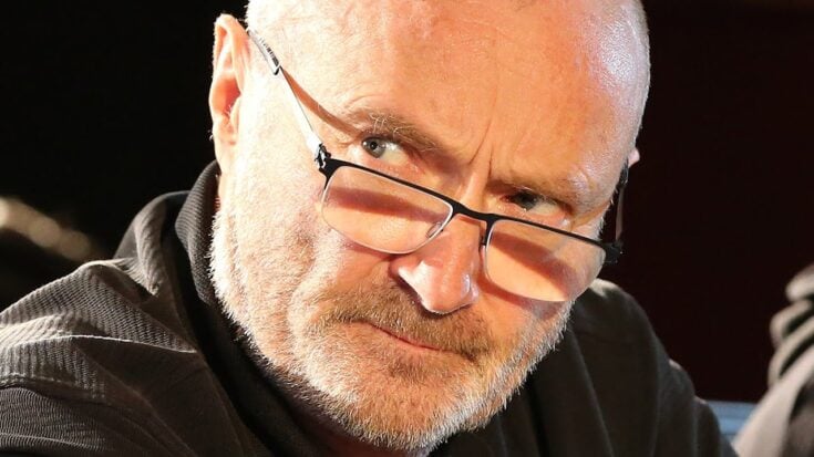 Phil Collins with a stern, intense expression, conveying visible frustration.