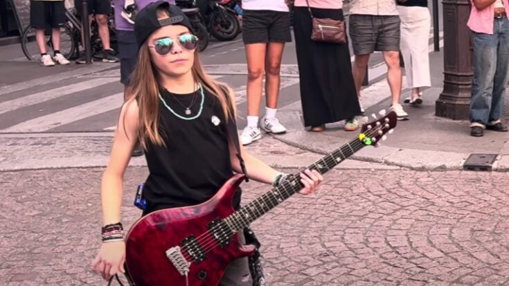 Olly Pearson, 11-year-old guitar prodigy, performing during a Paris flash mob tribute to Queen’s Bohemian Rhapsody, as the crowd looks on.