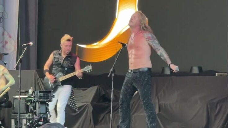 Chris Jericho performs shirtless on stage with FOZZY guitarist Rich Ward during their live cover of Ozzy Osbourne’s “Crazy Train.”