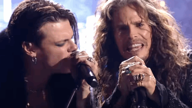 Steven Tyler and Yungblud performing together on stage, sharing an emotional rock music moment with microphones in hand.