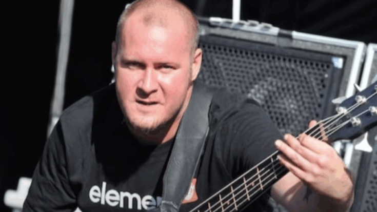 Limp Bizkit bassist Sam Rivers performing live on stage with his bass guitar.
