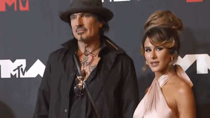 Tommy Lee and Brittany Furlan pose together on the red carpet at an MTV event, photographed amid renewed attention following a controversial social media post.