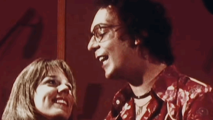 Snippet from the 1976 music video for “Afternoon Delight” by Starland Vocal Band, showing two members smiling and singing together in a warmly lit scene.