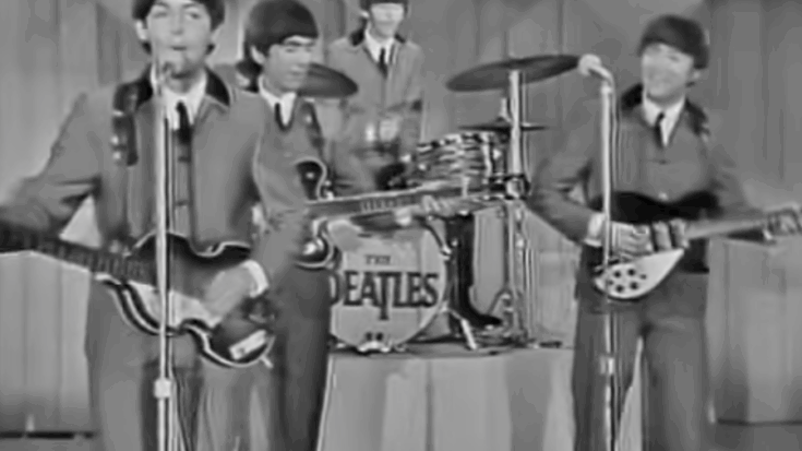 The Beatles performing live in the 1960s, with Paul McCartney, George Harrison, Ringo Starr, and John Lennon on stage in matching suits.