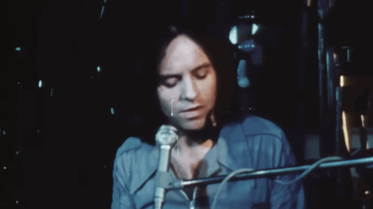 Eric Stewart of 10cc performing in the music video for the band’s 1975 hit “I’m Not in Love,” shown playing keyboard under soft stage lighting.