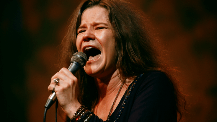 Janis Joplin performing passionately onstage, holding a microphone during an intense vocal moment.